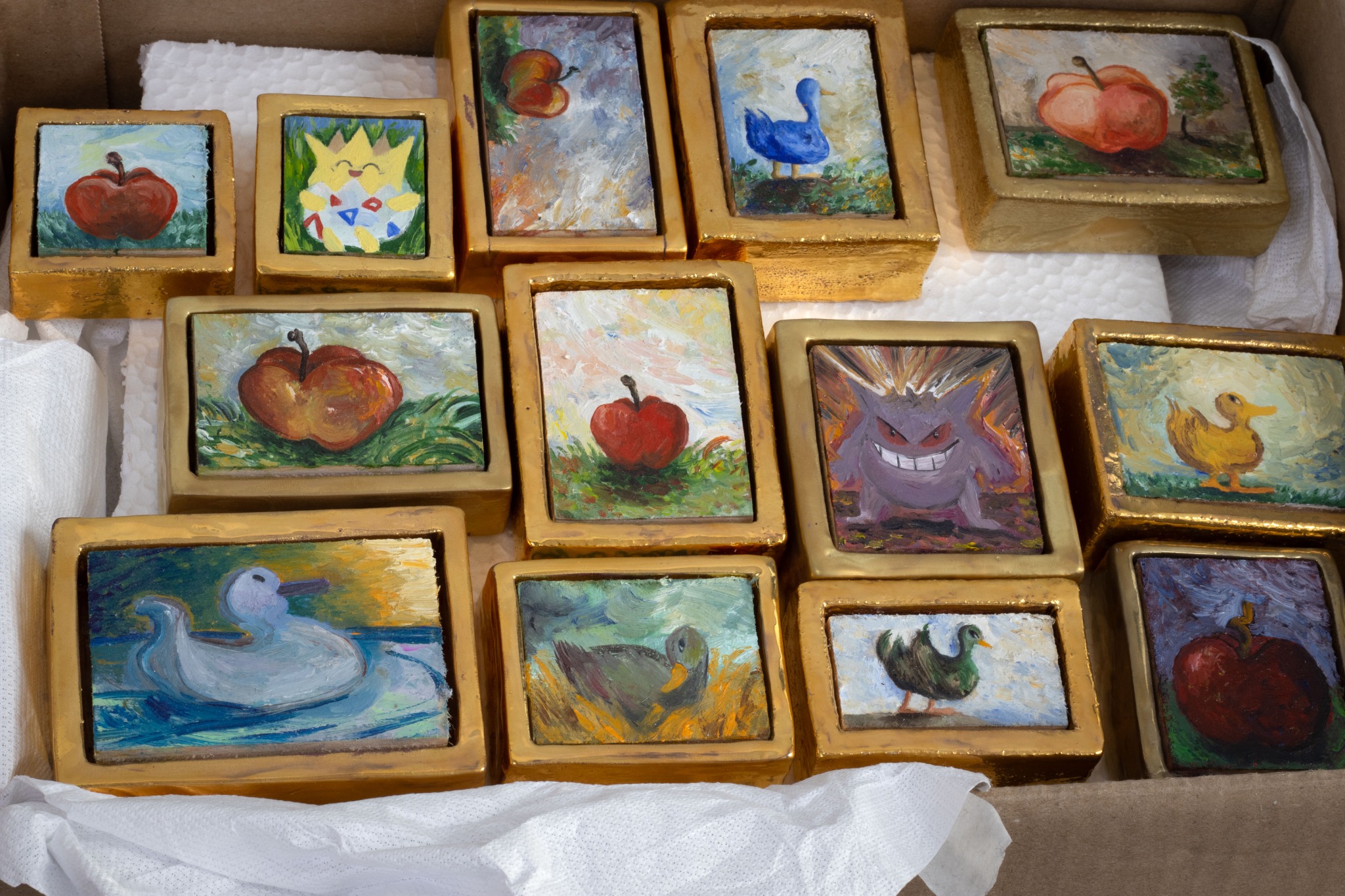 Peintures dans leurs cadres en céramique dorée